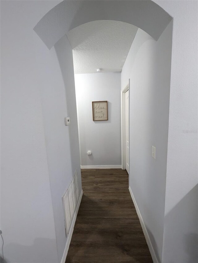 hallway featuring a textured ceiling and wood-type flooring