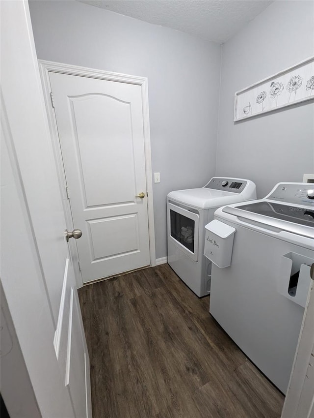 laundry area featuring washing machine and clothes dryer and dark hardwood / wood-style floors