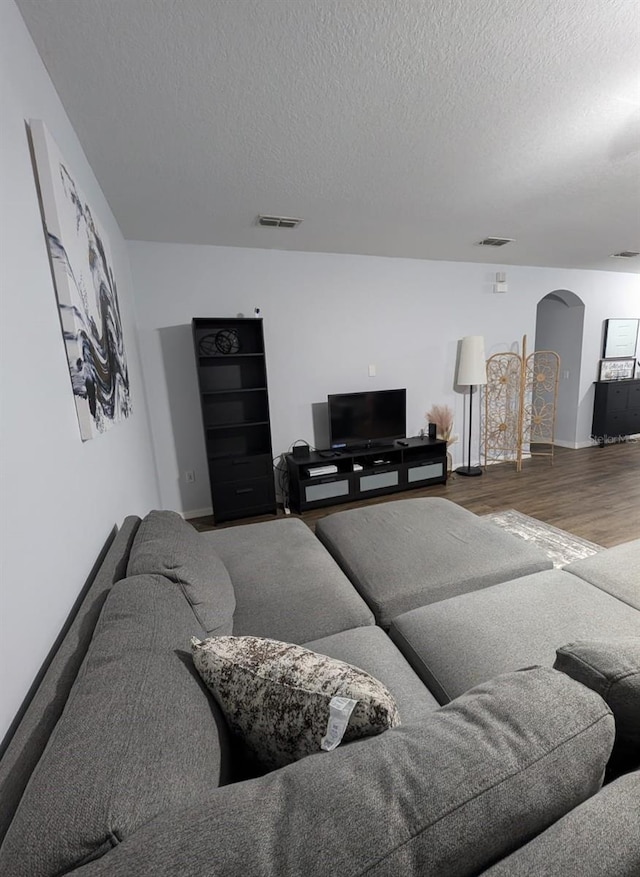 living room with a textured ceiling and hardwood / wood-style floors