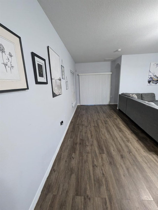 corridor with hardwood / wood-style flooring and a textured ceiling