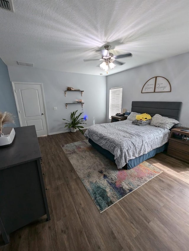 bedroom featuring hardwood / wood-style flooring, a textured ceiling, and ceiling fan