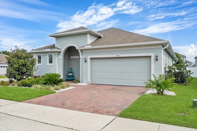 view of front of home with a garage and a front lawn