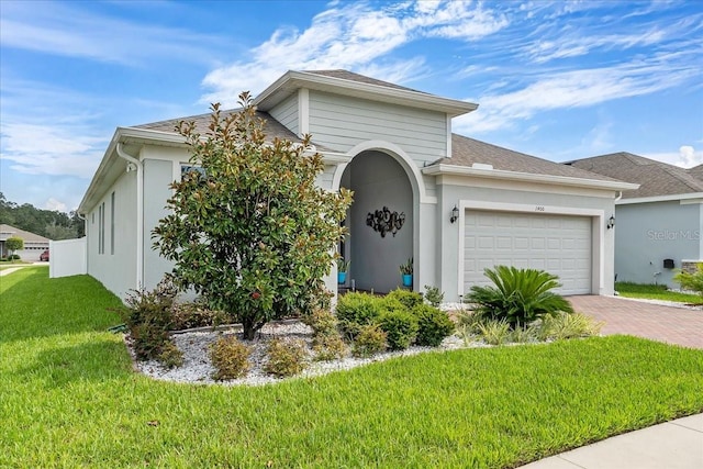 view of front of property featuring a garage and a front lawn