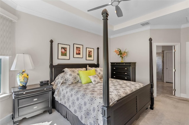 bedroom with a tray ceiling, ceiling fan, ornamental molding, and light carpet