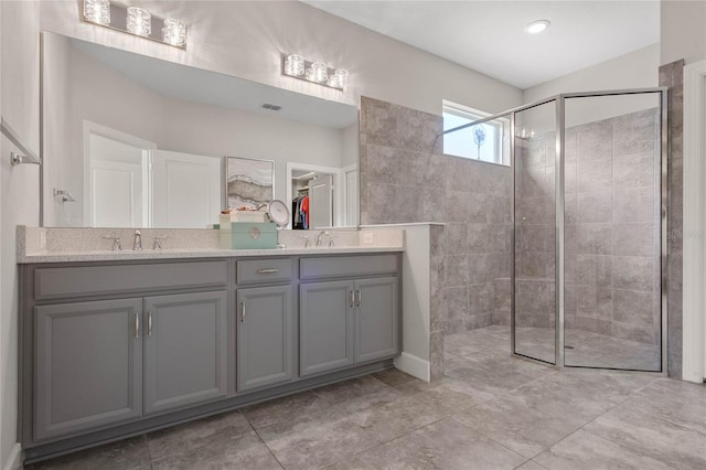 bathroom featuring tile patterned floors, double sink vanity, and walk in shower