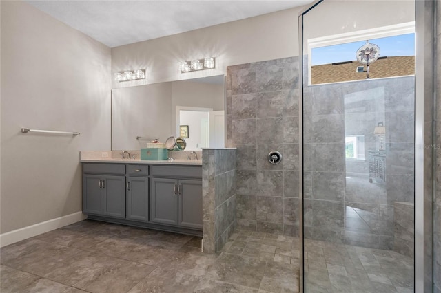 bathroom featuring tile patterned flooring, a tile shower, and dual vanity