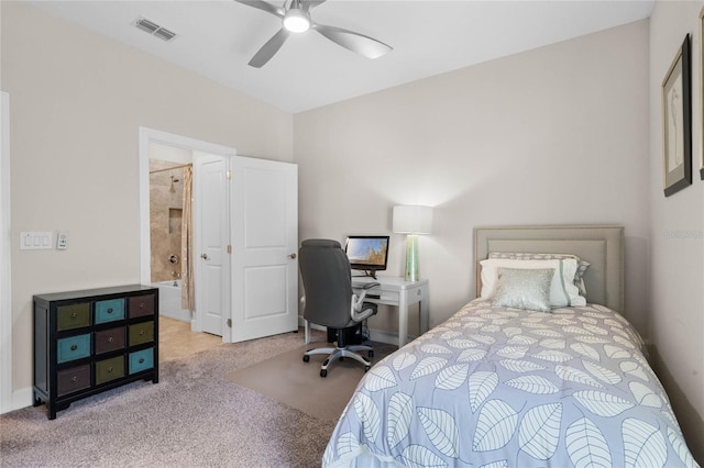 bedroom featuring ceiling fan, light colored carpet, and ensuite bath