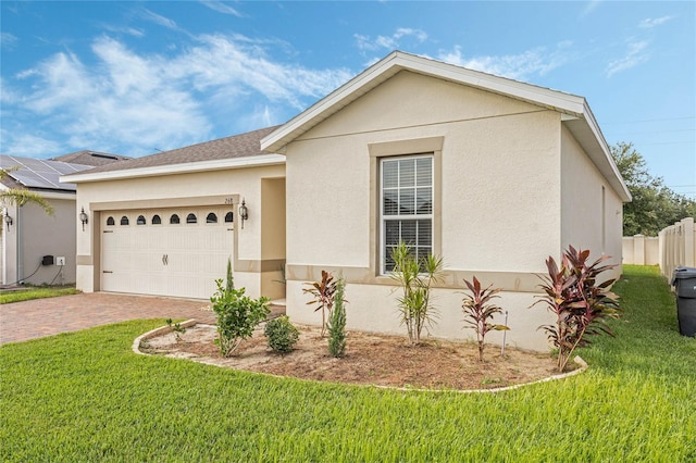 view of front of house with a front lawn, solar panels, and a garage