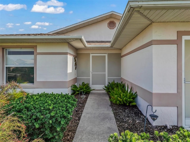 doorway to property featuring stucco siding
