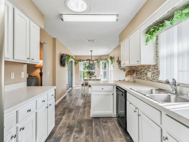 kitchen featuring a textured ceiling, dishwasher, white cabinetry, dark hardwood / wood-style floors, and kitchen peninsula