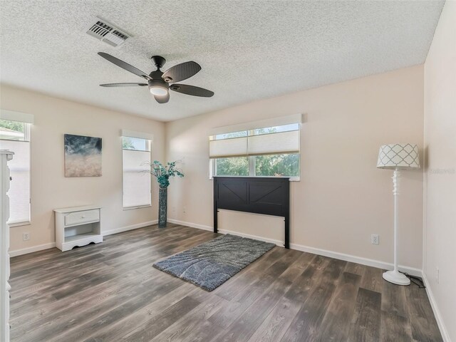 interior space with ceiling fan, dark wood-type flooring, and a textured ceiling