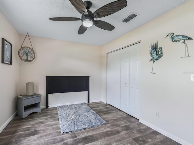 bedroom featuring wood finished floors, baseboards, a closet, and visible vents