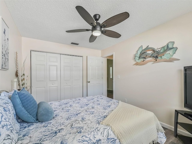 bedroom featuring a textured ceiling, a closet, ceiling fan, and hardwood / wood-style floors