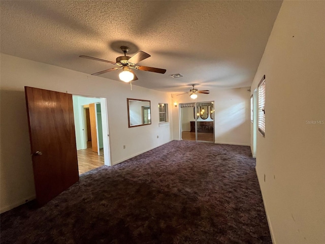 carpeted empty room featuring a textured ceiling and ceiling fan