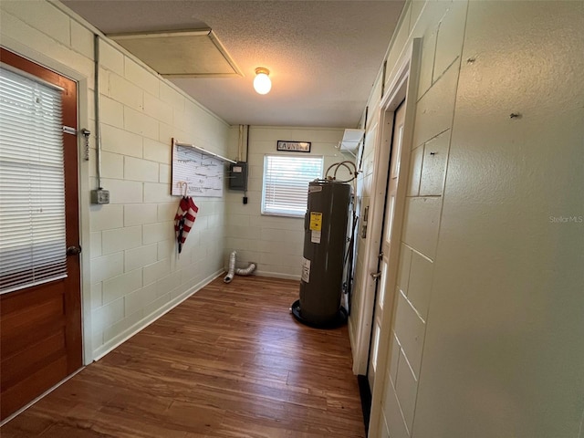 corridor featuring electric panel, water heater, hardwood / wood-style flooring, and a textured ceiling