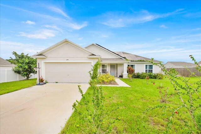 ranch-style house featuring a front yard, solar panels, and a garage