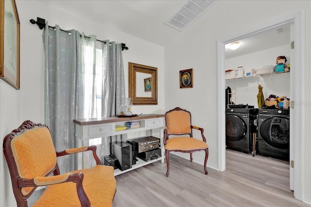 sitting room featuring washing machine and dryer and light hardwood / wood-style floors