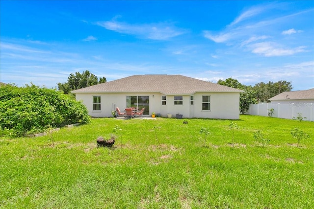 rear view of house featuring a lawn and a patio area