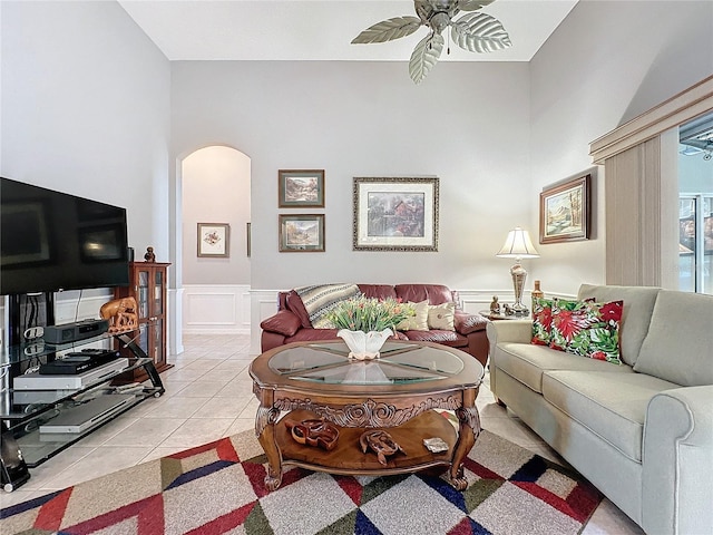 tiled living room featuring ceiling fan and a towering ceiling