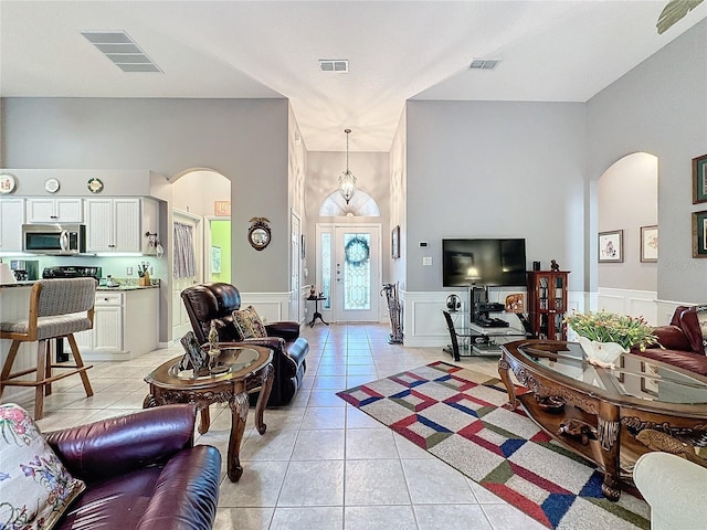 living room with light tile patterned floors and a towering ceiling