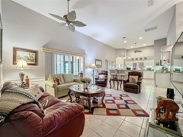 living room featuring ceiling fan, light tile patterned floors, and high vaulted ceiling