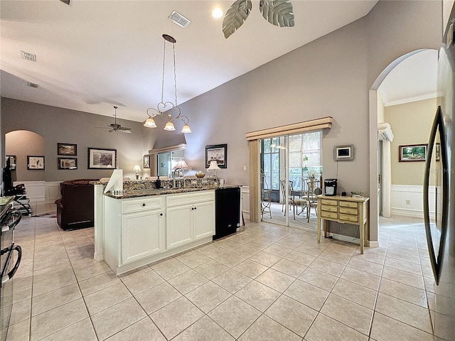 kitchen with ceiling fan, white cabinets, pendant lighting, dark stone countertops, and light tile patterned floors