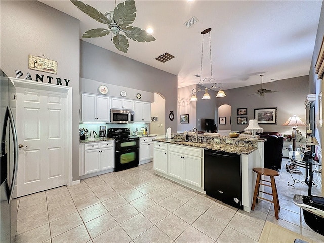 kitchen featuring dark stone countertops, stainless steel appliances, white cabinets, ceiling fan, and sink