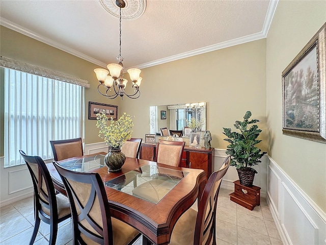 dining area with a notable chandelier, light tile patterned floors, a textured ceiling, and ornamental molding