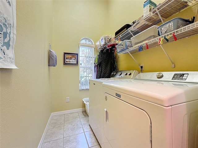 washroom with light tile patterned flooring and washing machine and clothes dryer