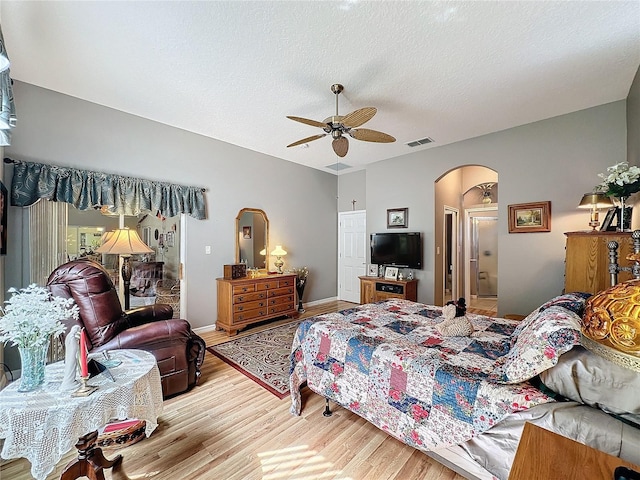 bedroom with ceiling fan, a textured ceiling, and light hardwood / wood-style floors