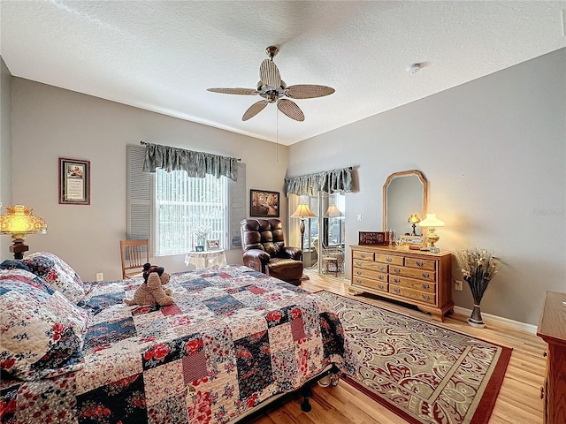 bedroom featuring a textured ceiling, light wood-type flooring, and ceiling fan