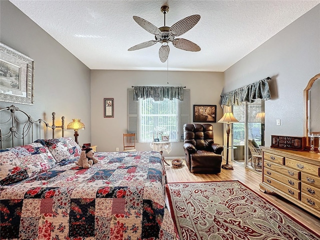 bedroom featuring ceiling fan, a textured ceiling, and light hardwood / wood-style floors