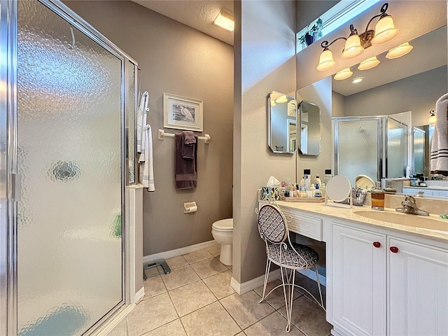 bathroom with toilet, tile patterned floors, vanity, and a shower with shower door