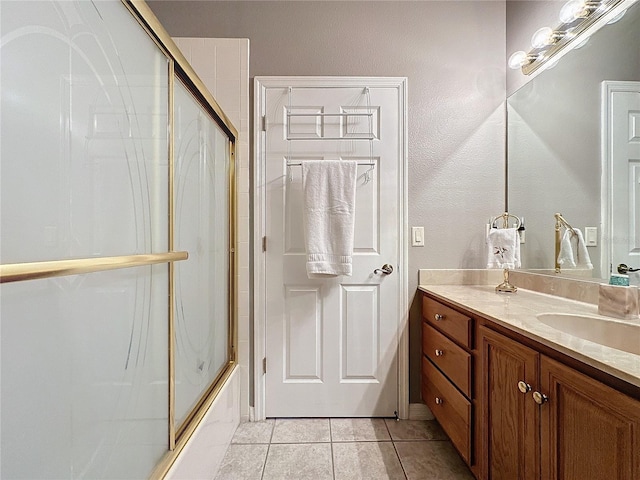 bathroom with tile patterned floors, vanity, and bath / shower combo with glass door