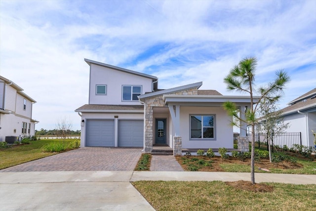 view of front facade featuring a garage, central AC unit, and a front lawn