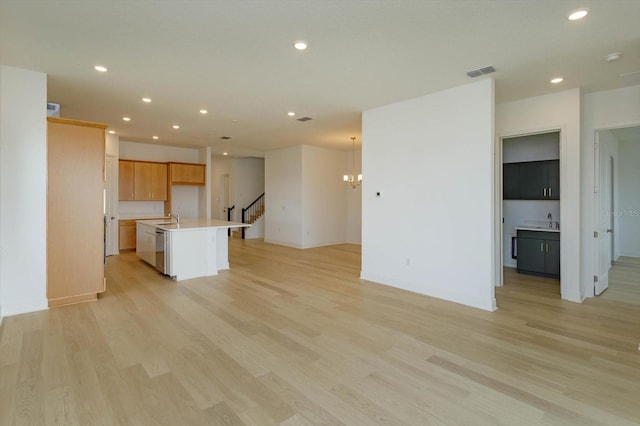 unfurnished living room featuring sink and light hardwood / wood-style flooring