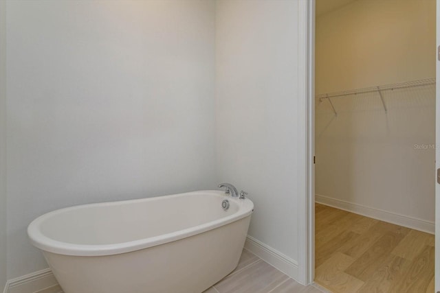 bathroom with a bath and wood-type flooring