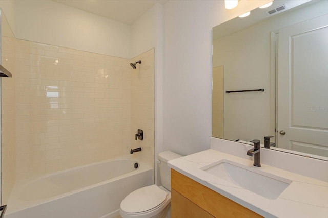 full bathroom with vanity, tiled shower / bath combo, and toilet