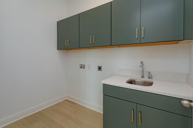 clothes washing area featuring sink, electric dryer hookup, cabinets, washer hookup, and light wood-type flooring