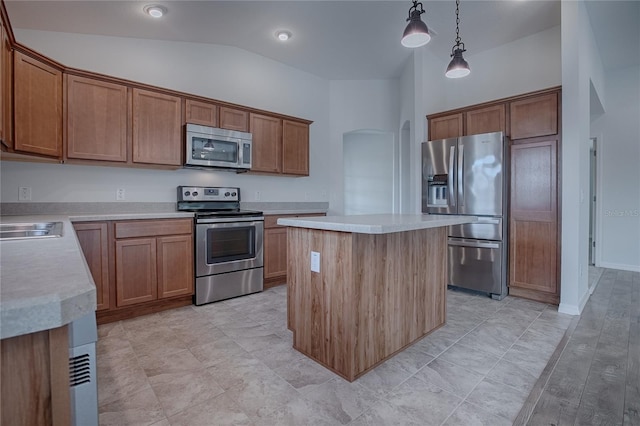 kitchen with lofted ceiling, a center island, decorative light fixtures, and appliances with stainless steel finishes