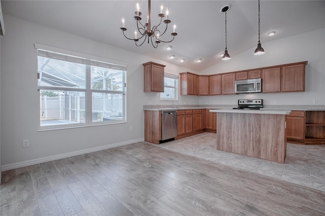 kitchen with a center island, light hardwood / wood-style floors, vaulted ceiling, and appliances with stainless steel finishes