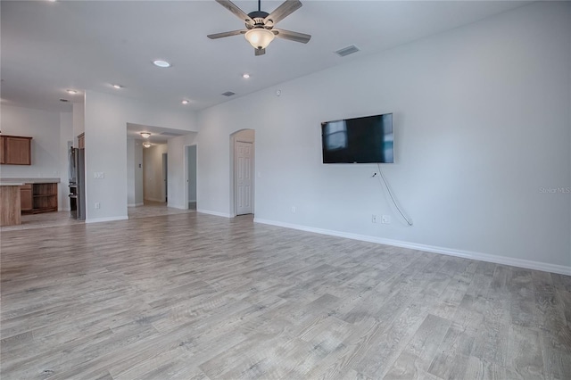 unfurnished living room featuring light wood-type flooring and ceiling fan