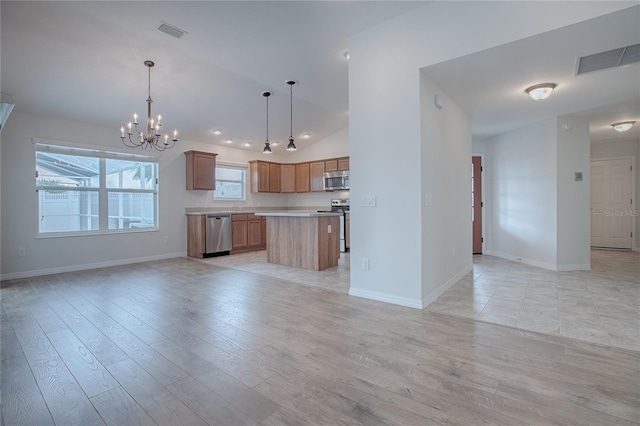 kitchen featuring a center island, hanging light fixtures, a chandelier, light hardwood / wood-style floors, and appliances with stainless steel finishes