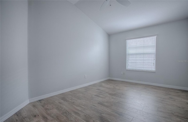 empty room with ceiling fan, lofted ceiling, and light wood-type flooring