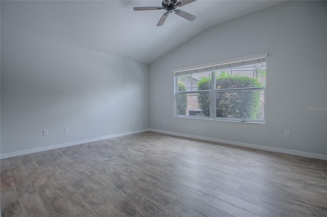 spare room with ceiling fan, vaulted ceiling, and light hardwood / wood-style flooring