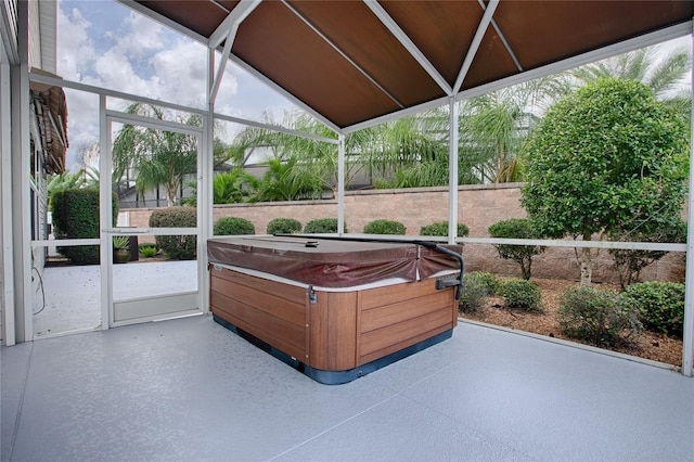 sunroom featuring vaulted ceiling, plenty of natural light, and a hot tub