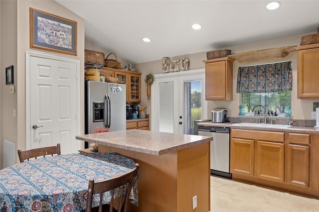 kitchen featuring sink, stainless steel appliances, a breakfast bar, and a kitchen island