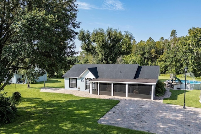 rear view of property with a yard and a sunroom