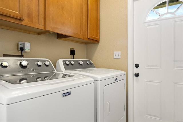 washroom with cabinets and washer and dryer