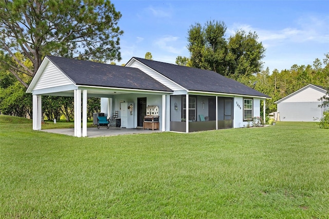 rear view of house with a yard, a patio area, and a sunroom